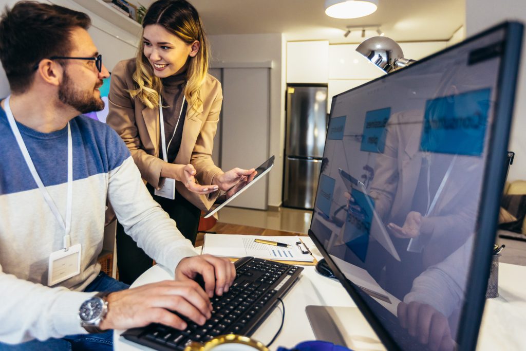 Young couple doing business together working at home on the comp